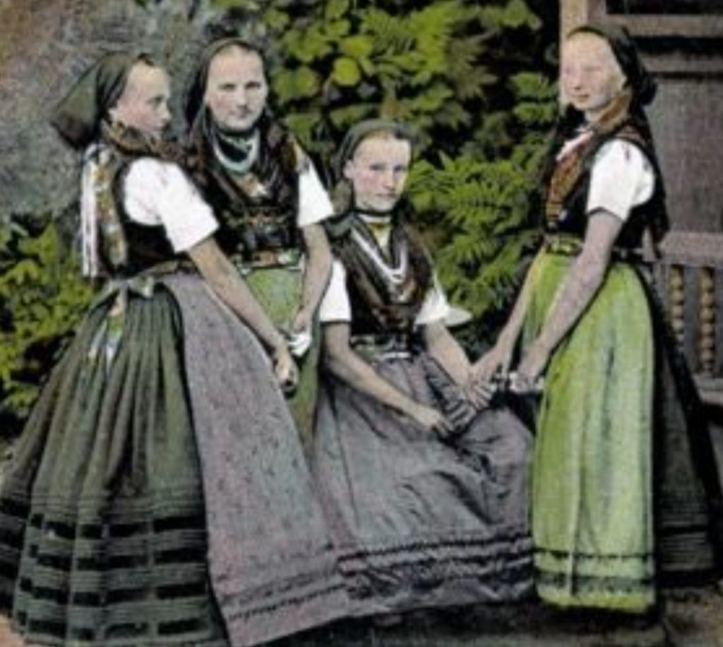 Vier Frauen in historischer Tracht des Dahmer Landes mit Miedern, langen Röcken, Schürzen, Brusttüchern und Schmuckbändern und Kopftüchern