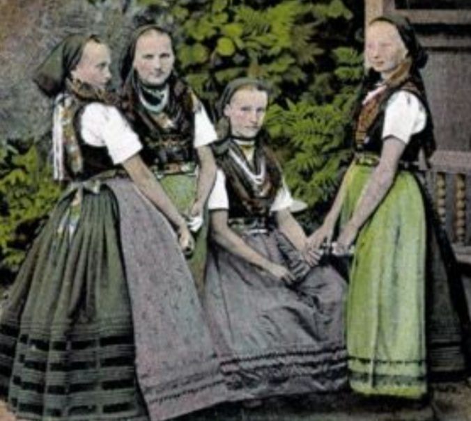 Vier Frauen in historischer Tracht des Dahmer Landes mit Miedern, langen Röcken, Schürzen, Brusttüchern und Schmuckbändern und Kopftüchern